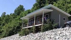 A two-story house with a balcony, surrounded by trees and a rocky landscape. - Cottage by the creek, beautiful Mountain View, perfect getaway!!! (Estillfork)