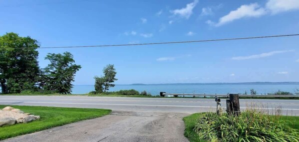 A road leading to a body of water with a clear sky.