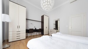 A modern hotel room with a large wardrobe, a desk, a chair, a bed, and a chandelier. - UR-NEST Marconi 2, Gorgeous and spacious one bedroom apartment (Bologna)