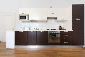 A modern kitchen with white and dark brown cabinets, a microwave, an oven, and a refrigerator. - UR-NEST Marconi 2, Gorgeous and spacious one bedroom apartment (Bologna)