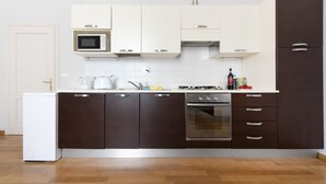 A modern kitchen with white and dark brown cabinets, a microwave, an oven, and a refrigerator. - UR-NEST Marconi 2, Gorgeous and spacious one bedroom apartment (Bologna)