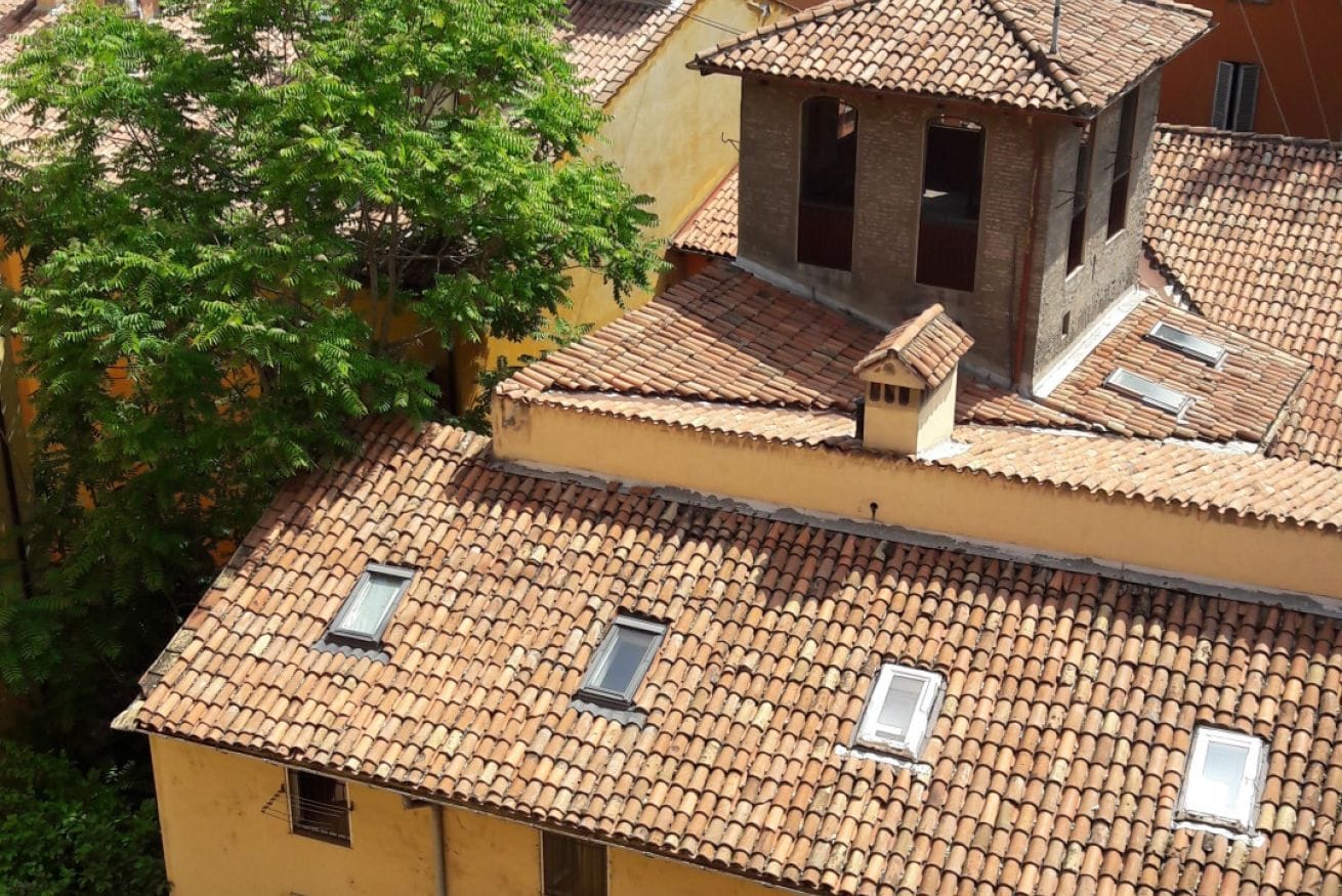 A building with multiple terracotta-tiled roofs and several small windows.