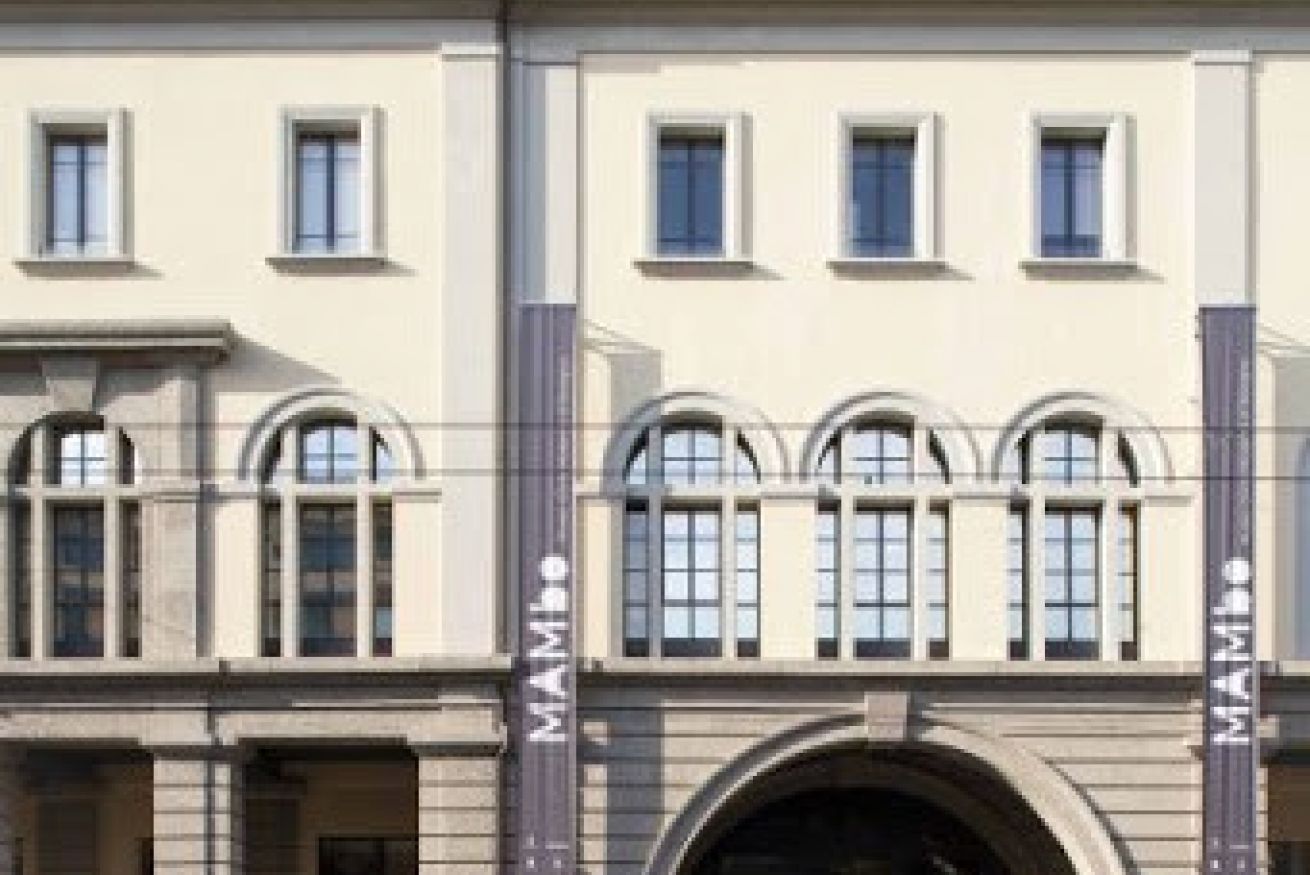 A building with a symmetrical facade, multiple windows, and a central entrance with an archway.