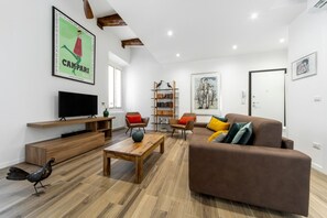 A modern living room with a flat-screen TV, a brown sofa, a wooden coffee table, and a bookshelf. - UR-NEST Val d'Aposa, Beautiful apartment (Bologna)