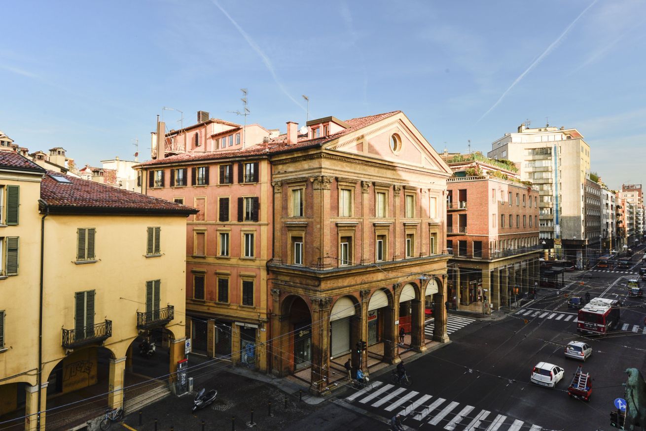 A street view with buildings, a crosswalk, and vehicles.