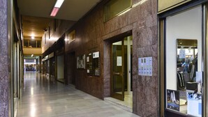 Un couloir avec un mur en bois, une porte en verre et une affiche accrochée au mur.