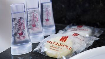 Botellas de acondicionador-champú METROPOLI y artículos de tocador envasados sobre una encimera.