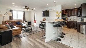 A modern kitchen with dark wood cabinets, a white countertop, and a built-in oven.
