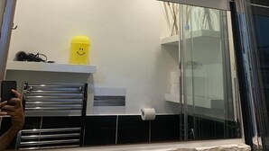 A bathroom with a large mirror, a yellow cup, and a toilet paper roll. - Guest house Biffi Simone (Florence)