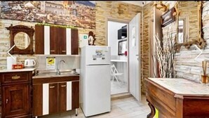 A compact kitchen with a refrigerator, a sink, and wooden cabinets. - Guest house Biffi Simone (Florence)