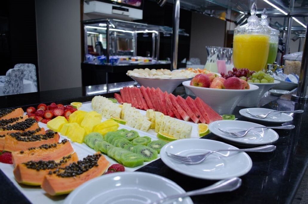 Un buffet proposant une variété de fruits et un distributeur de jus.
