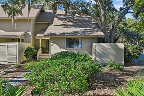 A two-story house with a front porch, a covered entryway, and a small front yard with shrubs. - Gorgeous Vacation Villa w/ Community Pool (Hilton Head Island)
