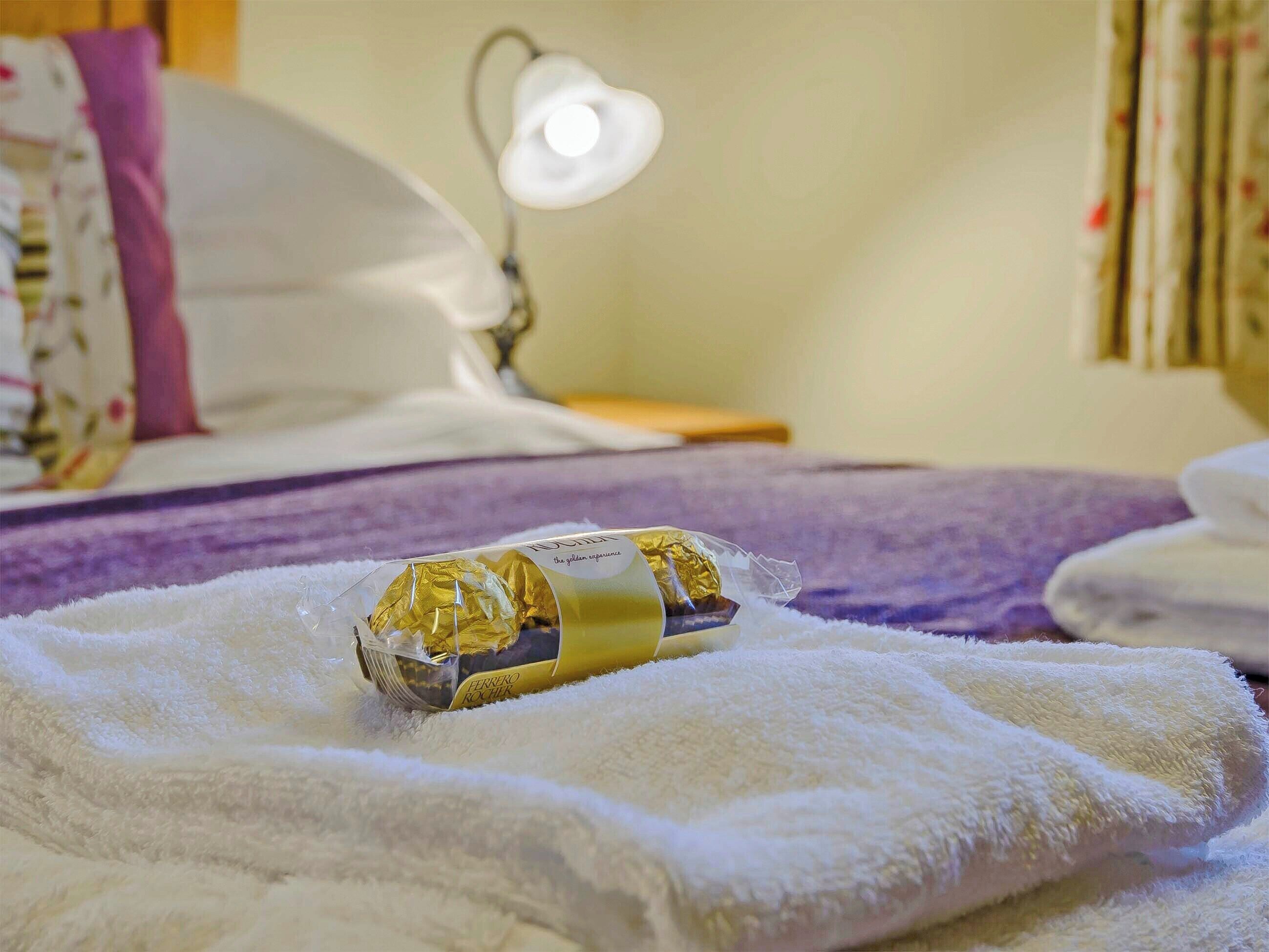 A bed with a white blanket, a pillow, and a lamp in a hotel room.