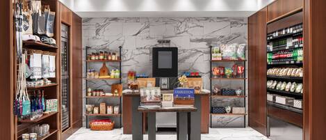 A modern retail space with wooden shelving, marble flooring, and a central table displaying various items.