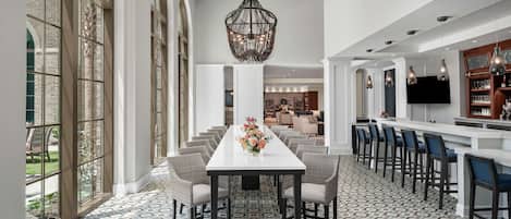 Un comedor amplio con una mesa larga, múltiples sillas y un centro de mesa decorativo.