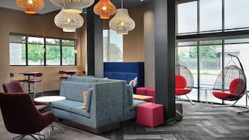 Un espacio lounge moderno con asientos, ventanas amplias e iluminación decorativa.