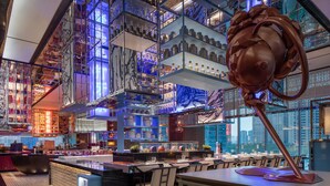 A modern bar with multiple levels of shelves and a large decorative sculpture. - W Chengdu (Chengdu)