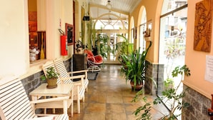 A corridor with wooden benches, potted plants, and a fire extinguisher. - Hotel São Paulo (Nova Friburgo)