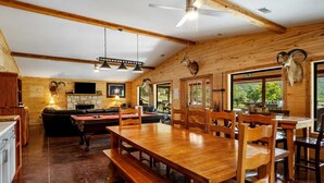 Un interior de madera con zona de comedor, chimenea y pared de piedra.