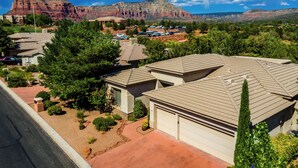A residential area with houses, a parking lot, and a view of red rock formations.