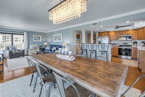 A spacious living area with a dining table, seating, and a kitchen with modern appliances.