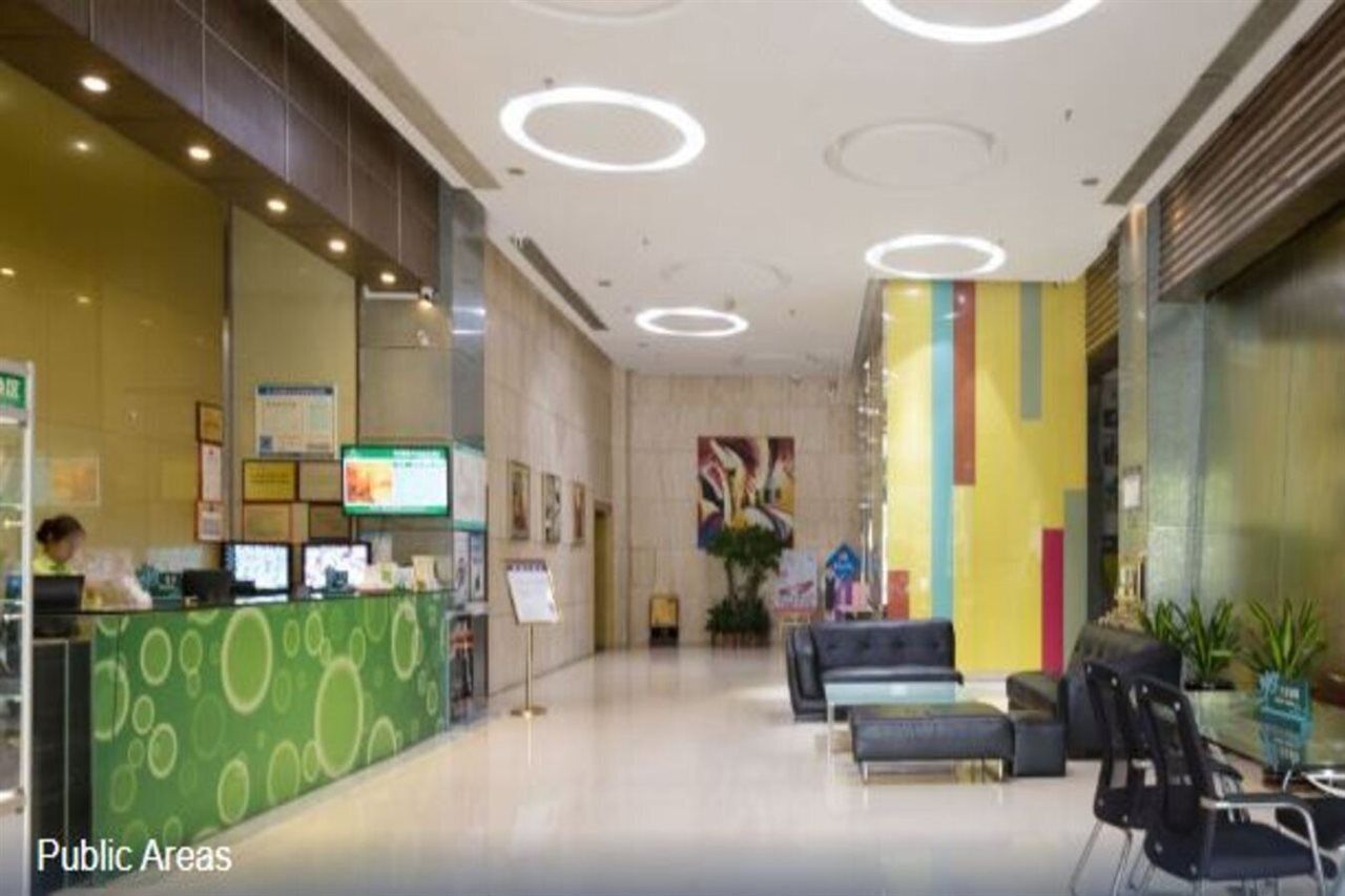 Eine Lobby mit einer Rezeption, einer Sitzecke und einem farbenfrohen Wandgemälde.