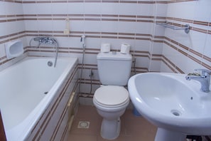 A small bathroom with a bathtub, toilet, and sink.