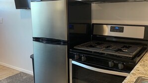 A modern kitchen with a stainless steel refrigerator, a microwave, a stove, and an oven. - Condo C at The St. Bernard (Sandpoint)