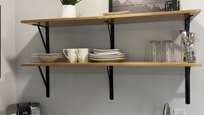 A kitchen with two wooden shelves, a coffee maker, and a sink. - Condo C at The St. Bernard (Sandpoint)