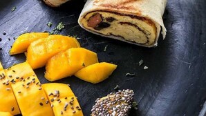 A plate with two wraps and sliced mangoes. - Reserva Natural El Encanto de Guanapalo (San Luis de Palenque)