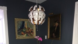 A dining area with a round table, four chairs, a vase with flowers, and two framed paintings on the wall. - Minutes to Midtown NYC, sunny, super clean modern 2 bedroom beautiful apartment (West New York)