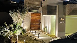 Ein modernes, zweistöckiges Haus mit markantem Eingang, einem Balkon und einer Garage.