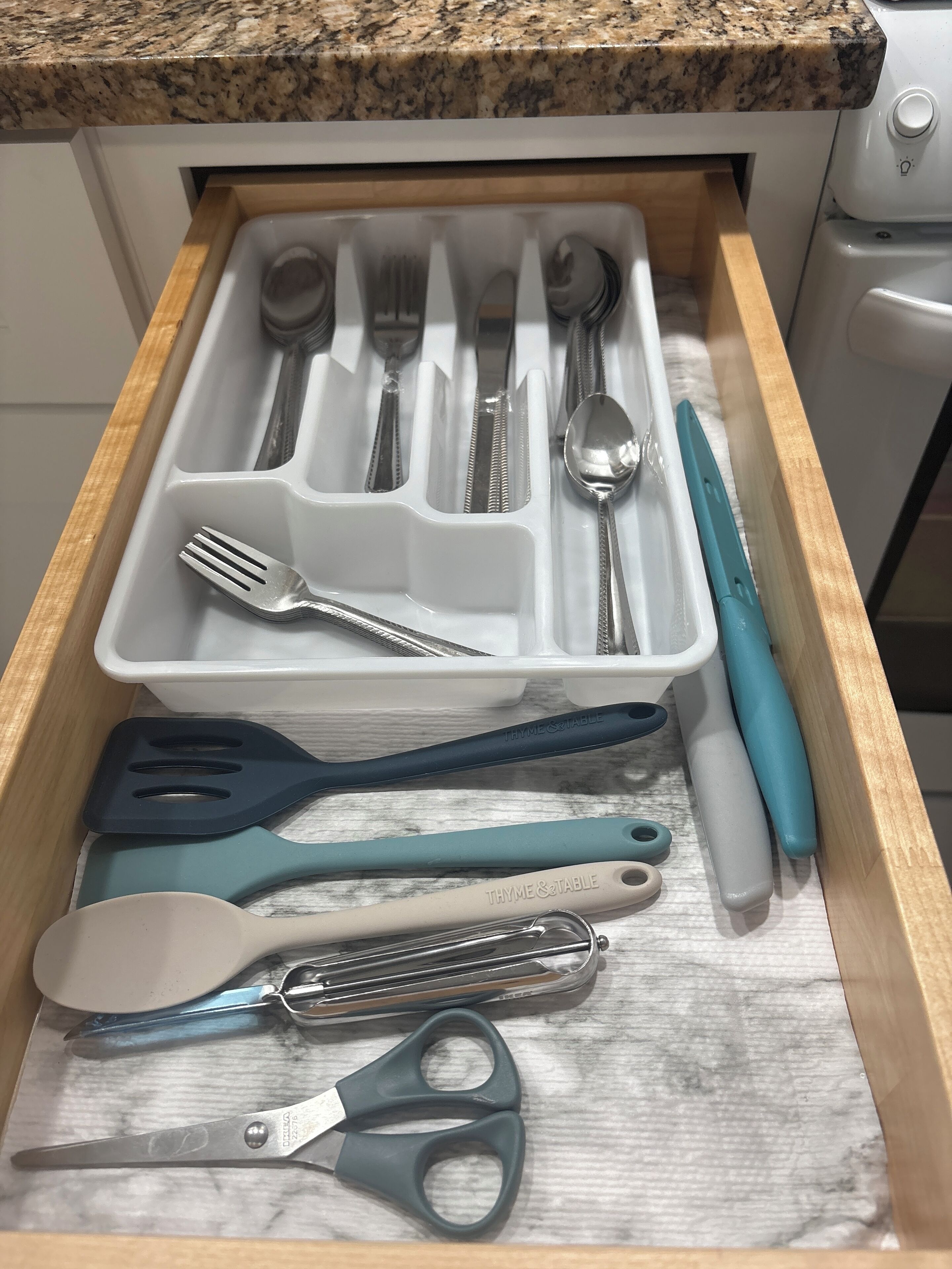 Un tiroir de cuisine contenant des ustensiles et des ustensiles de cuisine.