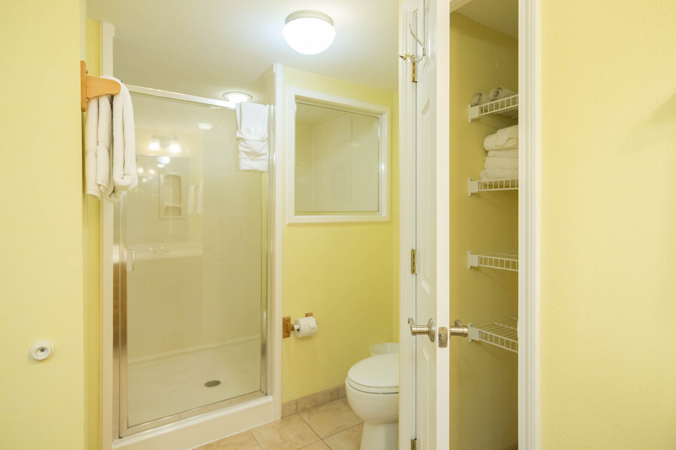 Ein Badezimmer mit Duschkabine aus Glas, Toilette und Handtuchhalter.