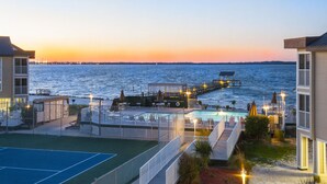 Ein Anwesen am Wasser mit Pool, Tennisplatz und einer anlegenden Anlegestelle.