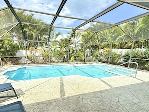 Ein überdachter Pool mit Blick auf die umliegende tropische Vegetation.