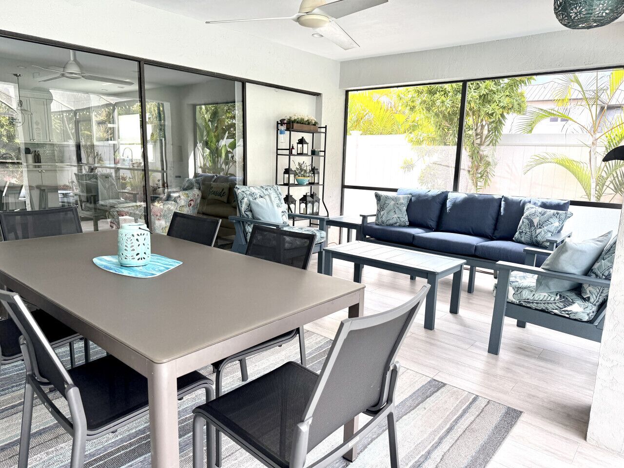 Un espace repas moderne avec une cloison en verre, une table à manger avec des chaises, un canapé avec des coussins et une table basse.