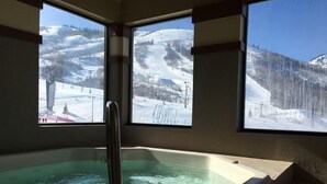 A spa area with a hot tub and large windows offering a view of a snowy mountain landscape. - Ski-In/Ski-Out Park City Mountain Resort 1BR+Loft Sleeps 6-A/C & Fireplace (Park City)
