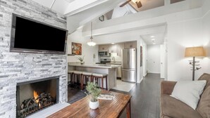 A modern living room with a fireplace, a flat-screen TV, a wooden coffee table, and a brown sofa. - Ski-In/Ski-Out Park City Mountain Resort 1BR+Loft Sleeps 6-A/C & Fireplace (Park City)