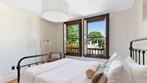 A bedroom with a bed, two windows, a ceiling light, and a view of greenery outside. - The Pearl, NH hidden luxury close to the Quinnipiac River in historic property (New Haven)