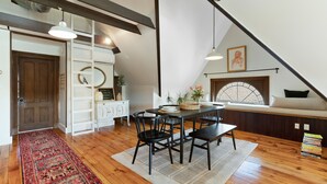 A dining area with a wooden table and chairs, a rug, and a window with a view. - The Pearl, NH hidden luxury close to the Quinnipiac River in historic property (New Haven)