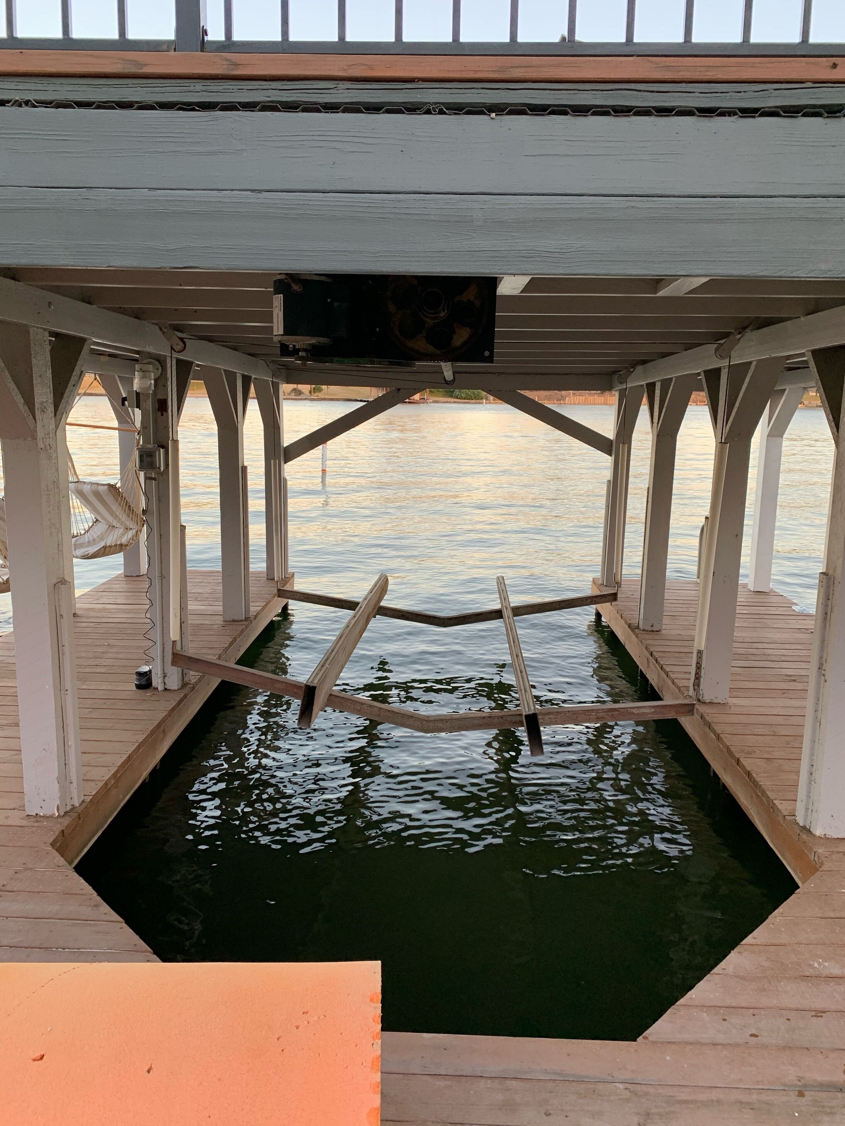 A wooden deck with a hammock and a small pool.