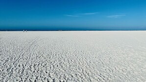A vast, white sandy beach under a clear blue sky. - MarcoView 402 - A Slice of Paradise! Premier Waterfront Location @Anglers Cove! (Marco Island)