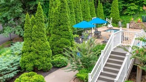 Relax in a serene outdoor space surrounded by lush greenery and a small pool.