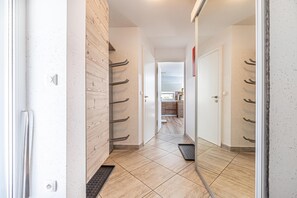 A hallway with a wooden wall, a metal handrail, and a tiled floor leading to a kitchen area. - Pool Villa Katja near Kranjska Gora, Gozd Martuljek, Slovenia (Gozd Martuljek)