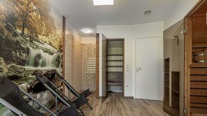 Une pièce dotée d’un plancher en bois, d’une fresque représentant une cascade et d’une porte coulissante donnant sur un espace de rangement.