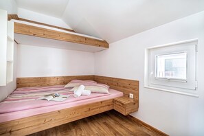A bedroom with a bunk bed, a small bedside table, a window, and a wooden floor. - Pool Villa Katja near Kranjska Gora, Gozd Martuljek, Slovenia (Gozd Martuljek)
