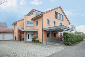 Une maison à deux étages dotée d’un porche abrité, d’un garage et d’un jardin bien entretenu.