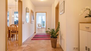 A hallway with a dining area, a plant, and a view into another room. - Apartment 'Haus Sonnenseite Säntis' with Mountain View, Balcony and Wi-Fi (Wasserburg)