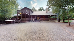 A rustic lodge with a covered porch, a stone chimney, and a gravel driveway. - Winding Creek Lodge 5+ Bedroom 5 Bathroom w/ Gameroom Near Broken Bow Lake! (Broken Bow)